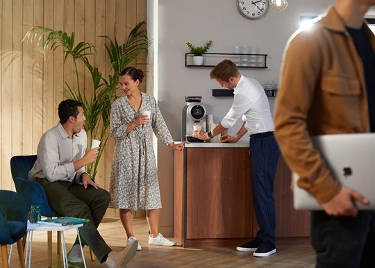 Collega's aan een koffiemachine