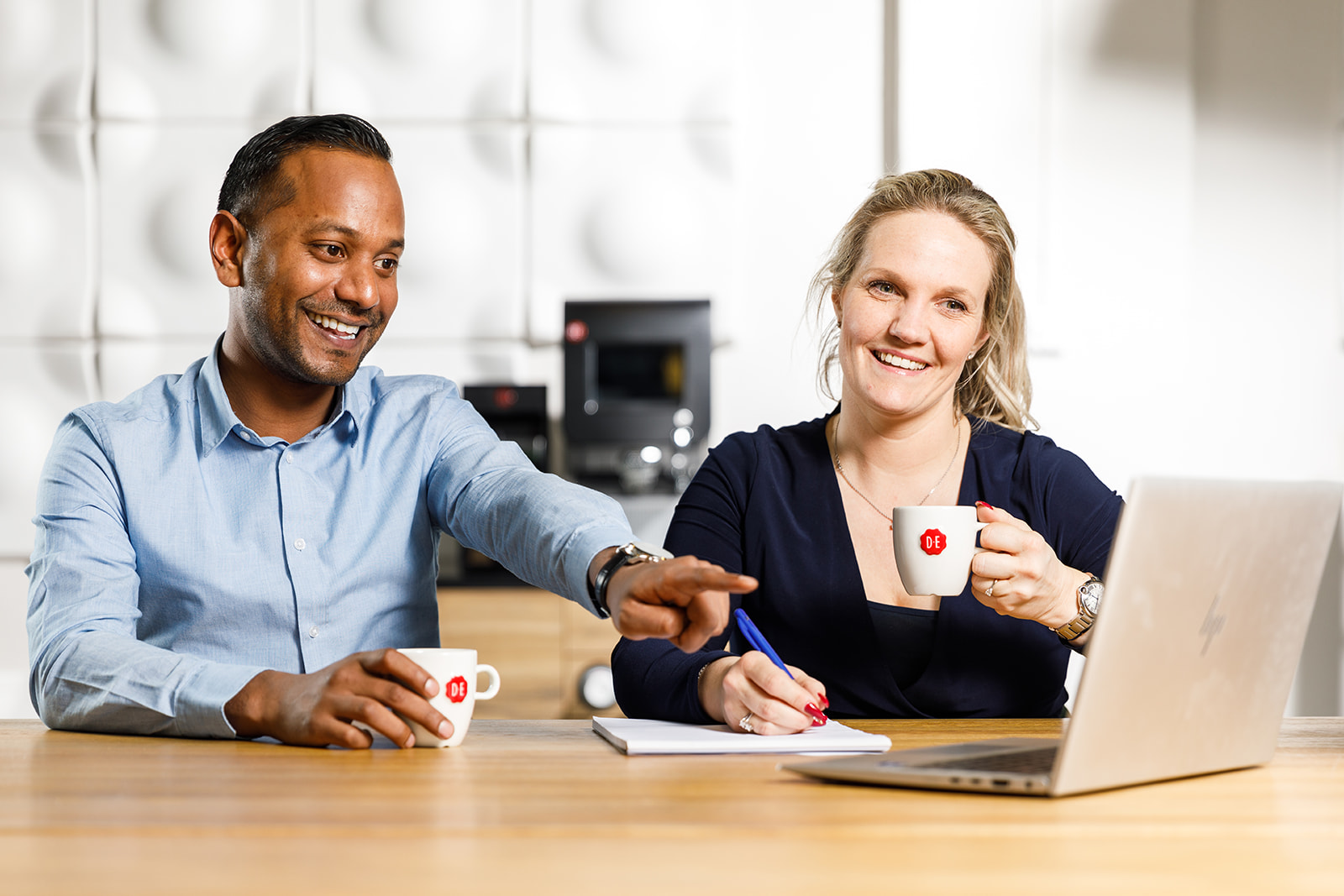 een man en vrouw met een laptop en koffie