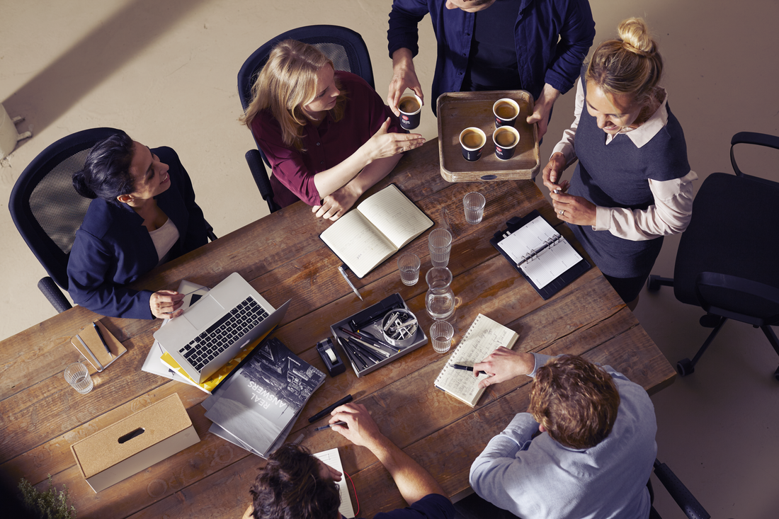 mensen in een vergadering delen koffie uit